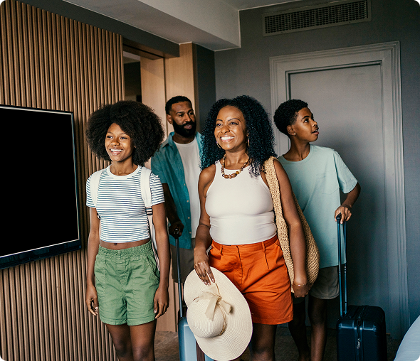 Family entering hotel room with luggage